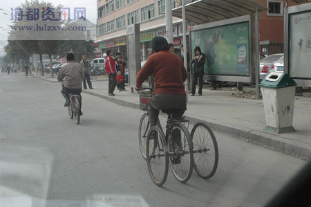一名依姆骑着一辆改装后的四轮自行车行驶在路