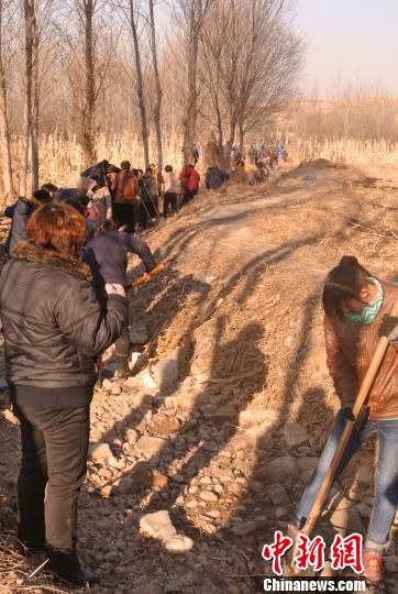 听说当地政府组织清理苯胺污染物，沿途多数村民自带工具开始清污。　李新锁 摄