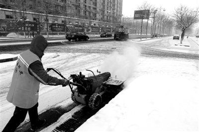 昨日，密云新北路，一名工人在清理路面上的冰雪。拍者 高烈权