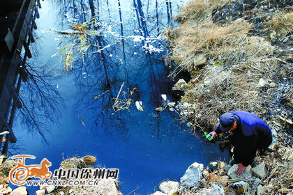 薛庄大沟上有一座小桥，当地村民称为“三井桥”。在“三井桥”附近，村民从河边盛水取样给记者看。