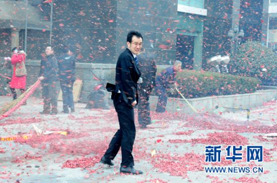 2月9日，一名大连市民在街头被大风刮起的鞭炮碎片包围。新华社发(吕文正 摄)