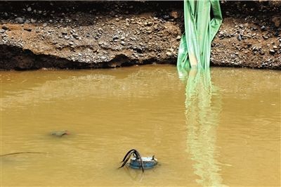 盗采沙者遗留在大坑里的水泵刚停止工作不久，便被冒出的地下水没过。