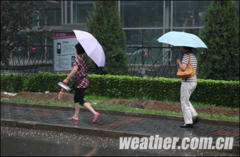 中午时分 京城开始出现降雨 路人纷纷打伞避雨(关禹 摄)