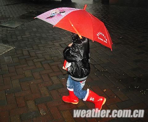 今晨7时,主城气温低迷,一小学生穿上了加棉的雨靴出行.