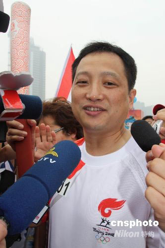 图为第一棒火炬手羽毛球世界冠军杨阳传递后接受访问.