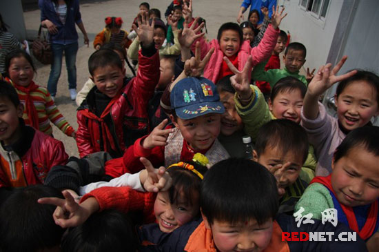 (抢镜。) 再过几天,常立龙又要去四川绵竹的九龙小学了,上一次去看那些孩子们,还是半年前。 24岁的常立龙在成都一家私企工作,遭受地震后的九龙小学,是公司的对口援助学校。今年3月,公司组织员工去做志愿者,为板房里的孩子们义务讲课。有同事教唱歌,有同事教英语。喜爱摄影的常立龙,则用公司送给九龙小学的电脑,教孩子们一些简单的图片处理技巧。(链接网址:常立龙选送的漂亮笑脸照) 绵竹是5.