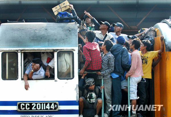 9月18日,在印度尼西亚首都雅加达一火车站,人们站在火车车厢的连接