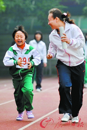 "一名老师跟跑在孩子身边不断地鼓励他.