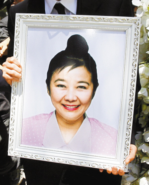 2007年4月18日,在龚如心的葬礼上,其养子张雁坤拿着她的遗像.