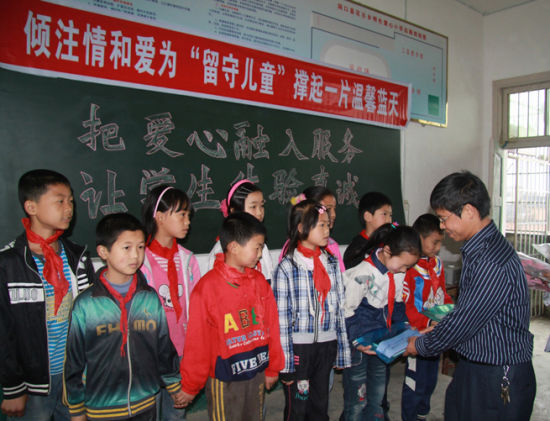 人冒雨来到花古乡明伦爱心小学,开展为留守儿童撑起一片温馨蓝天活动