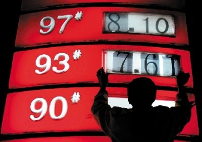 今日零时,加油站工作人员将93号汽油新的价格放入标识牌.
