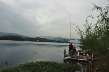 6月12日,市民在三岔湖边钓鱼.