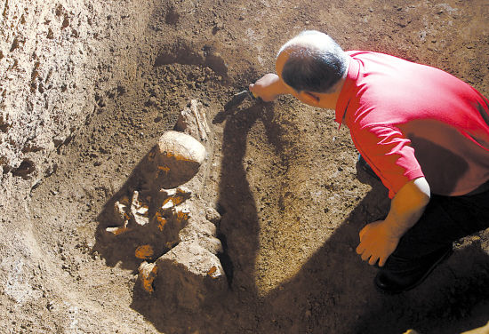 图为考古人员在洛阳某古墓发掘现场清理出一具盗墓贼骸骨 cfp 供图