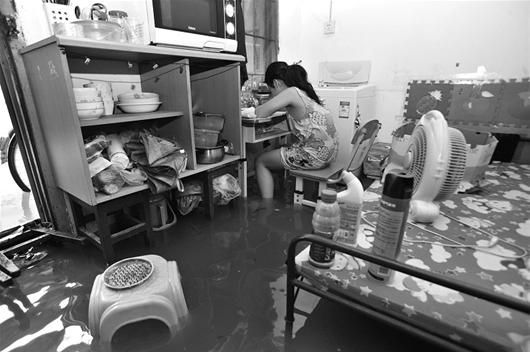 图文:一场暴雨淹了四排房 学生水中写作业