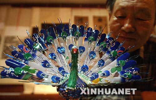 张焕林在展示他用废旧易拉罐制作的孔雀