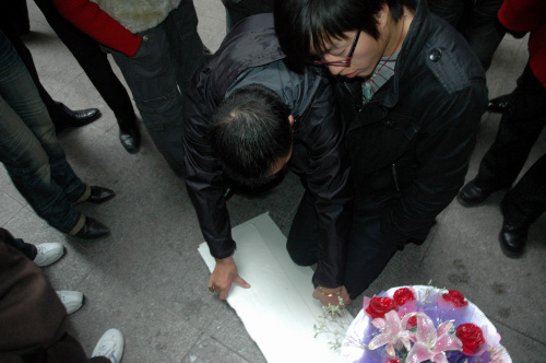 青年疑为恋爱受挫持花跪地数小时(图)