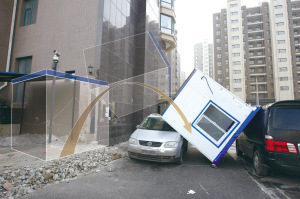 大风将街边板房吹起砸中轿车(图)