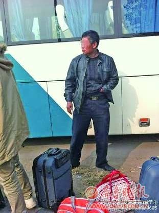 大巴司机（图中男子）让旅客把行李搬下车来，随后自己开车返回青岛。(黄女士供图）