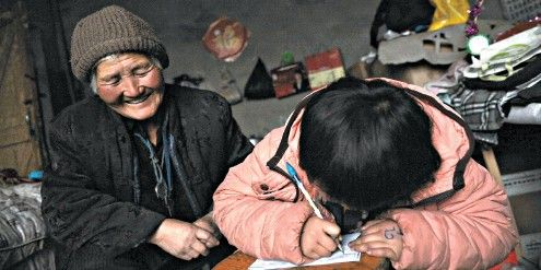 李显梅陪孙女写作业。孙女很懂事，是老人最大的骄傲。
