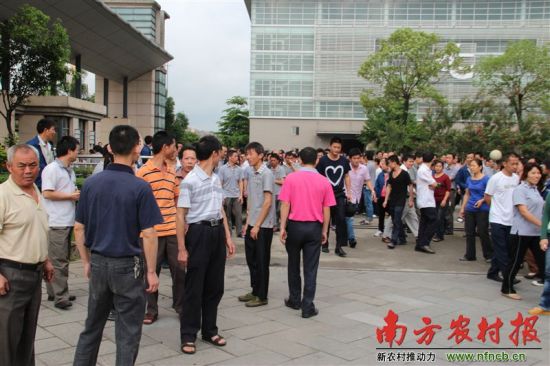 4月24日，东莞台升家具有限公司部分员工打卡“上班”后来到厂办公楼前，等待与厂方的谈判结果。