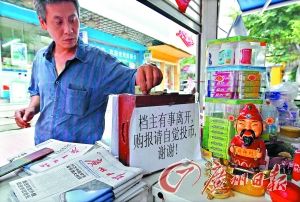 市民在欧婆婆的报亭自觉投钱买报。 市民在欧婆婆的报亭自觉投钱买报。