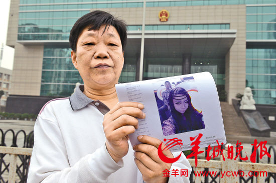老父亲昨天在法院前展示女儿生前的照片 