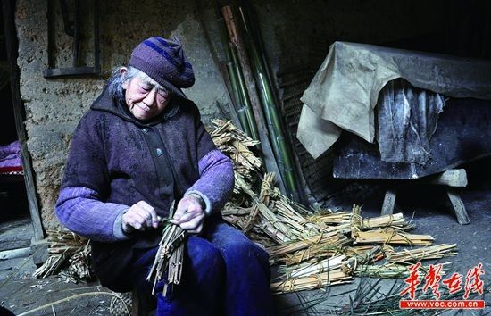 12月9日，67歲的莫秋蓮一邊捆著柴火，一邊不停念叨“我怎麽還不死”。她身旁擺放的棺木已經預備了14年。實習記者 李健 攝