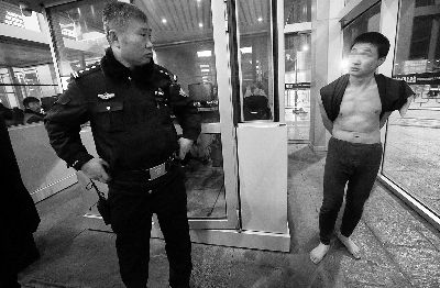 裸奔男子被民警拦住后，意识仍然有些不清醒 摄/法制晚报记者 杨益