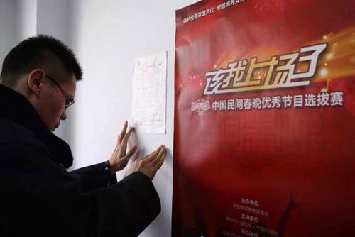 朝阳法院工作人员将民事传票张贴在民间春晚办公区内。新京报记者 周岗峰 摄