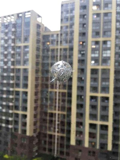 因邻楼男孩偷买气枪射击,朝阳光熙家园一住户窗玻璃留下弹痕。 新京报记者 王大鹏 摄 因邻楼男孩偷买气枪射击,朝阳光熙家园一住户窗玻璃留下弹痕。 新京报记者 王大鹏 摄