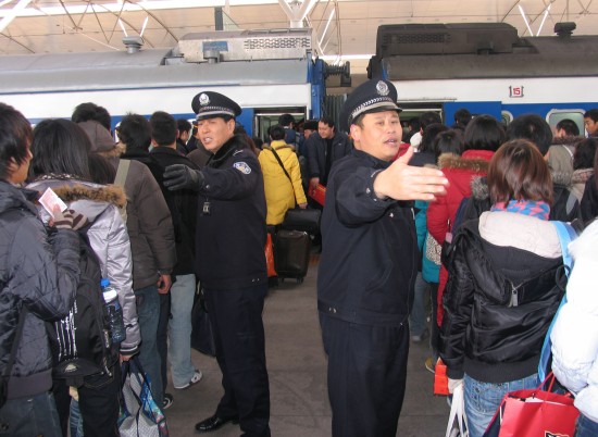 图文:天津乘警在引导T253次列车旅客上车
