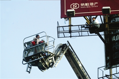 男子因感情问题爬上30米广告牌4小时(组图)