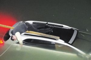 昨日凌晨，临朐县民主路弥河段，被困河中的司机因体力不支，晕倒在车顶上。记者 于蓓蕾 摄