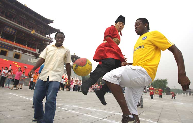 图文:身着唐装青年和非洲留学生踢足球