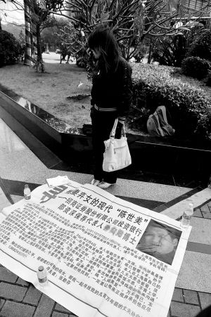 昨日上午，记者在江苏大厦楼下见到下跪妻子的妹妹，在地上放置着一张“罪状单”。　　深圳商报记者 胡嘉伟 摄