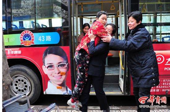 43路公交女司机王曼利将行动不便的乘客王萌萌抱下公交车 本报记者 李晖 摄