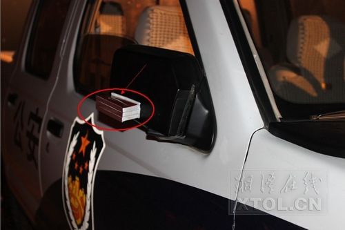 另一辆警车反光镜上绑着的火柴盒（记者 李景辉摄影）