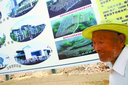 一位村民站在老井新社区的规划图旁。