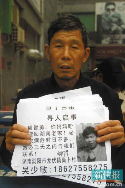 ■周淋漓拿着寻人启事在广州继续寻找儿子。 ■周淋漓拿着寻人启事在广州继续寻找儿子。