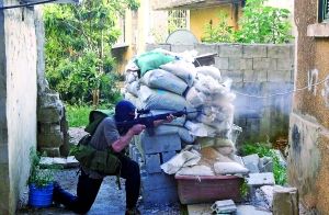 昨日，在黎巴嫩北部城市的黎波里，一名武装人员持枪做好交火准备。新华/法新