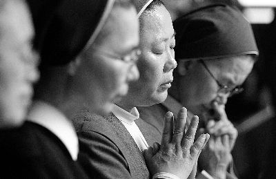 20日，韓國修女在首爾為沉沒客輪失蹤乘客祈禱圖/IC