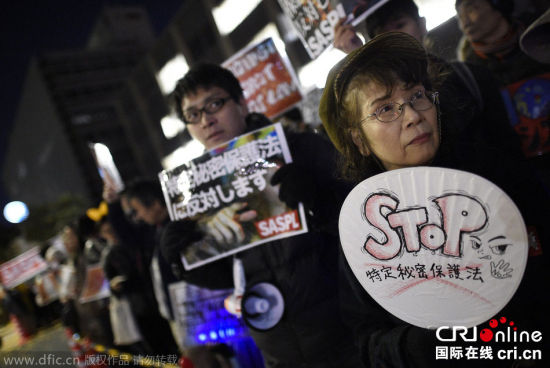 当地时间2014年12月9日，在日本东京，有示威者手持标牌抗议将于10日生效的《特定秘密保护法》。