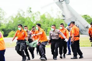 印度尼西亚庞卡兰布翁的伊斯坎德尔空军基地，救援人员和警察正在搬运遇难者遗体。新华社发