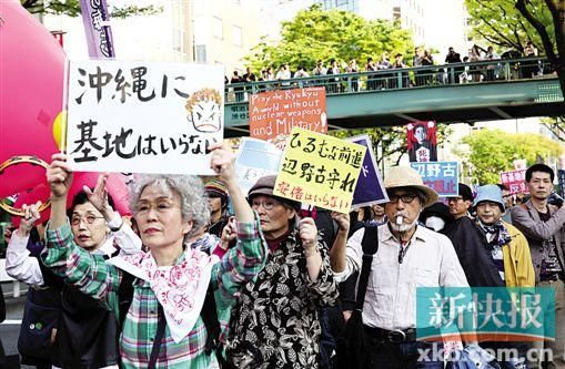 4月26日,在日本东京,人们在示威游行上举起标语。