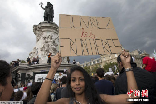 一名示威女性高举写有“开放边境”的牌子。德媒报道称，在经过长时间犹豫后，<strong></strong>默克尔开始处理难民话题。