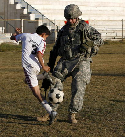 图文:士兵与足球训练营的孩子们在一起踢球