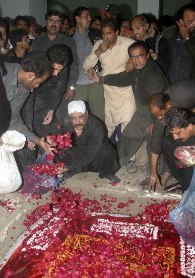 图文：扎尔达里向妻子的墓穴抛撒鲜花
