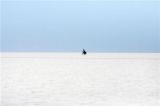 图文：男子骑车行走在玻利维亚南部盐湖上