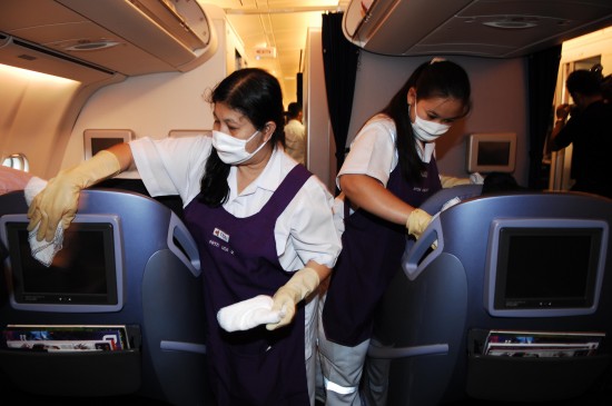 图文:曼谷机场工作人员擦拭客机里的座椅