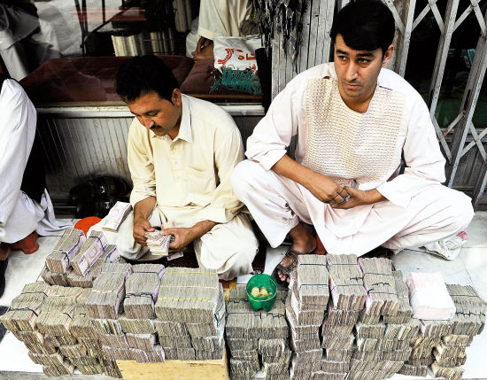 8月10日，喀布尔一家外汇交易市场的职员在清点阿富汗尼。当日，阿富汗尼对美元汇率升至47∶1